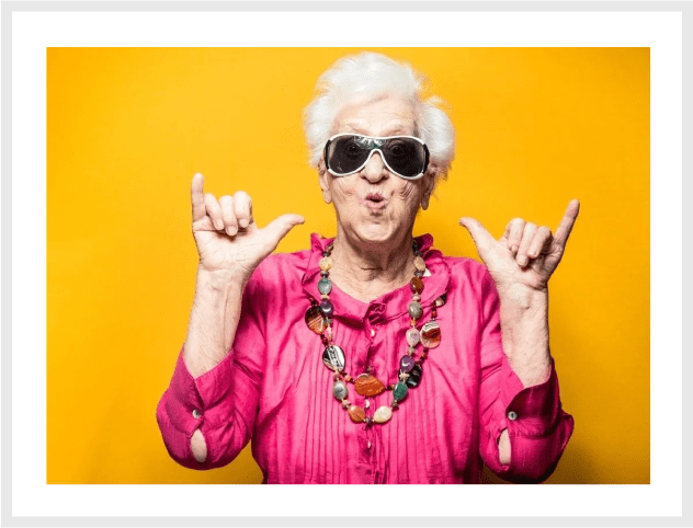 A woman with sunglasses and a necklace is making an angry face.