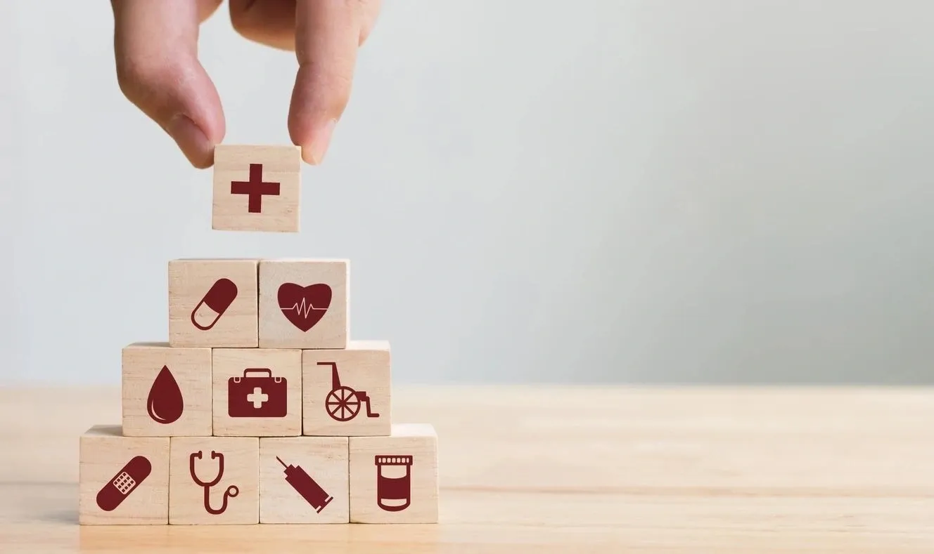 A hand is holding a cube with medical symbols on it.