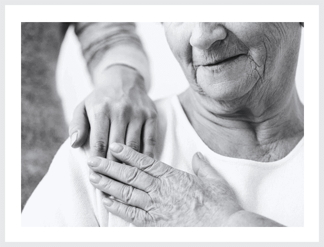 A close up of an older person holding someone 's hand