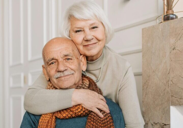 A man and woman hugging each other in front of stairs.